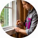 Lead carpenter measuring trim beside a newly installed residential window